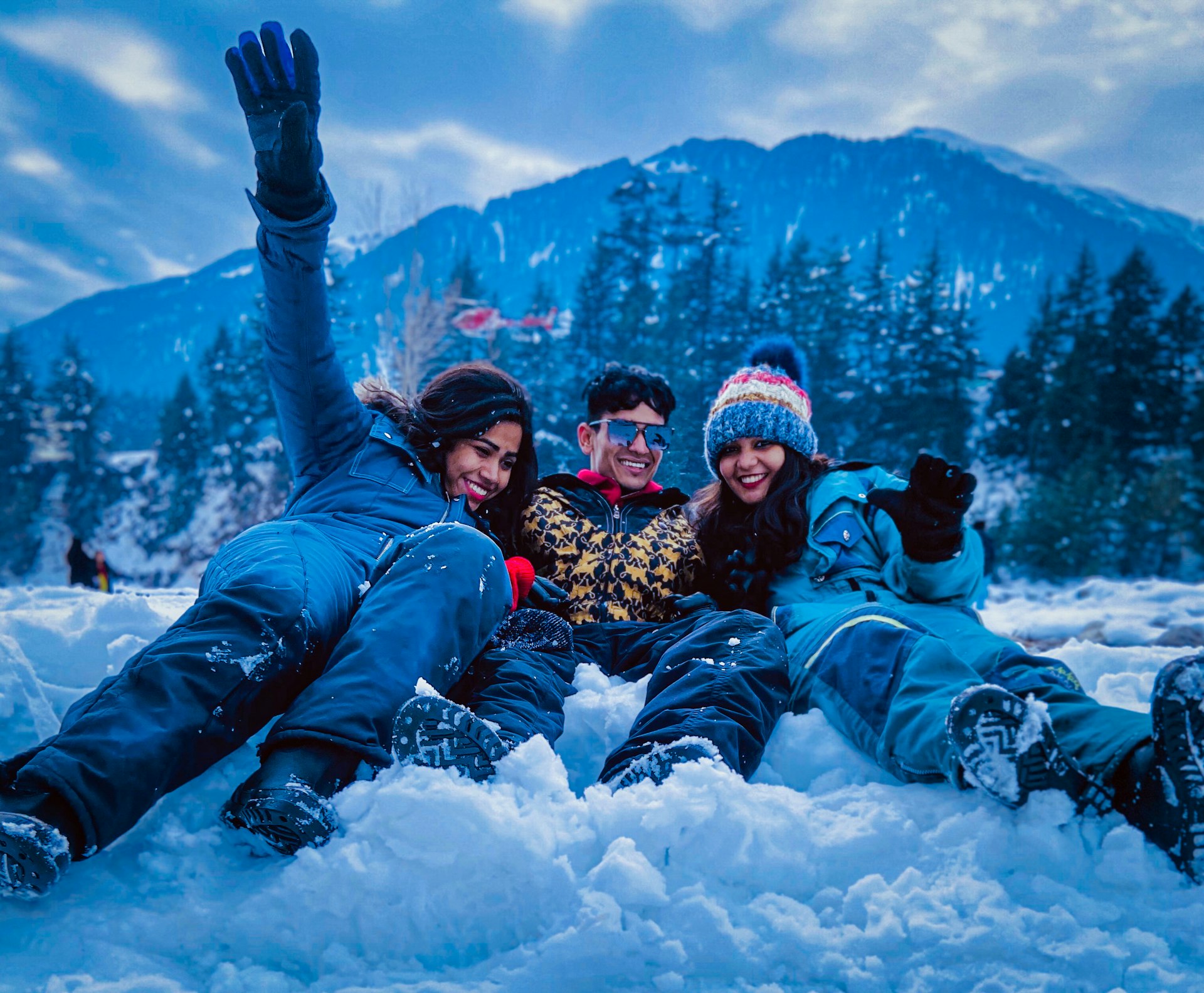 3 women lying on snow covered ground during daytime